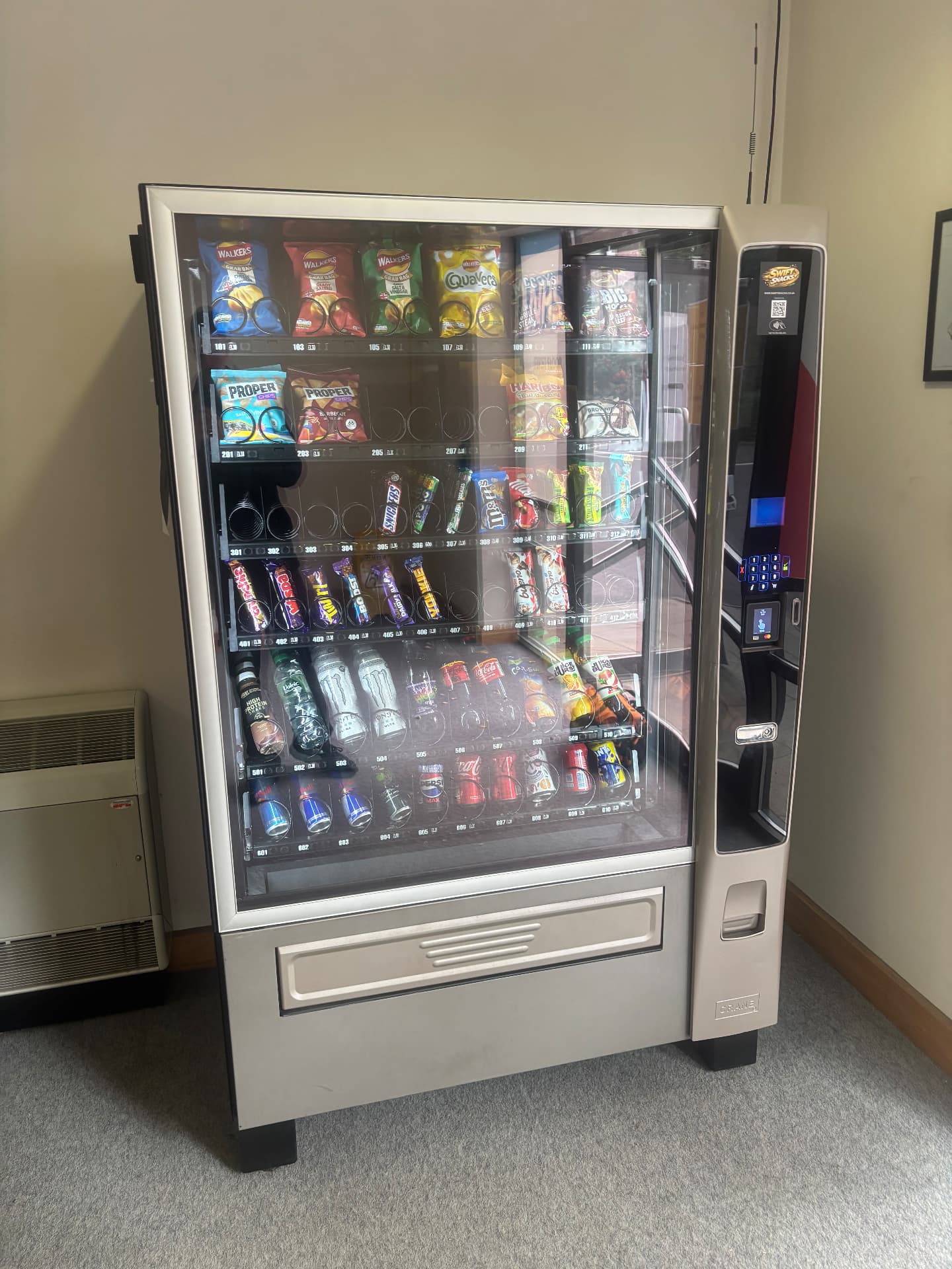 Swift Snacks vending machine with a contact code sticker on the glass